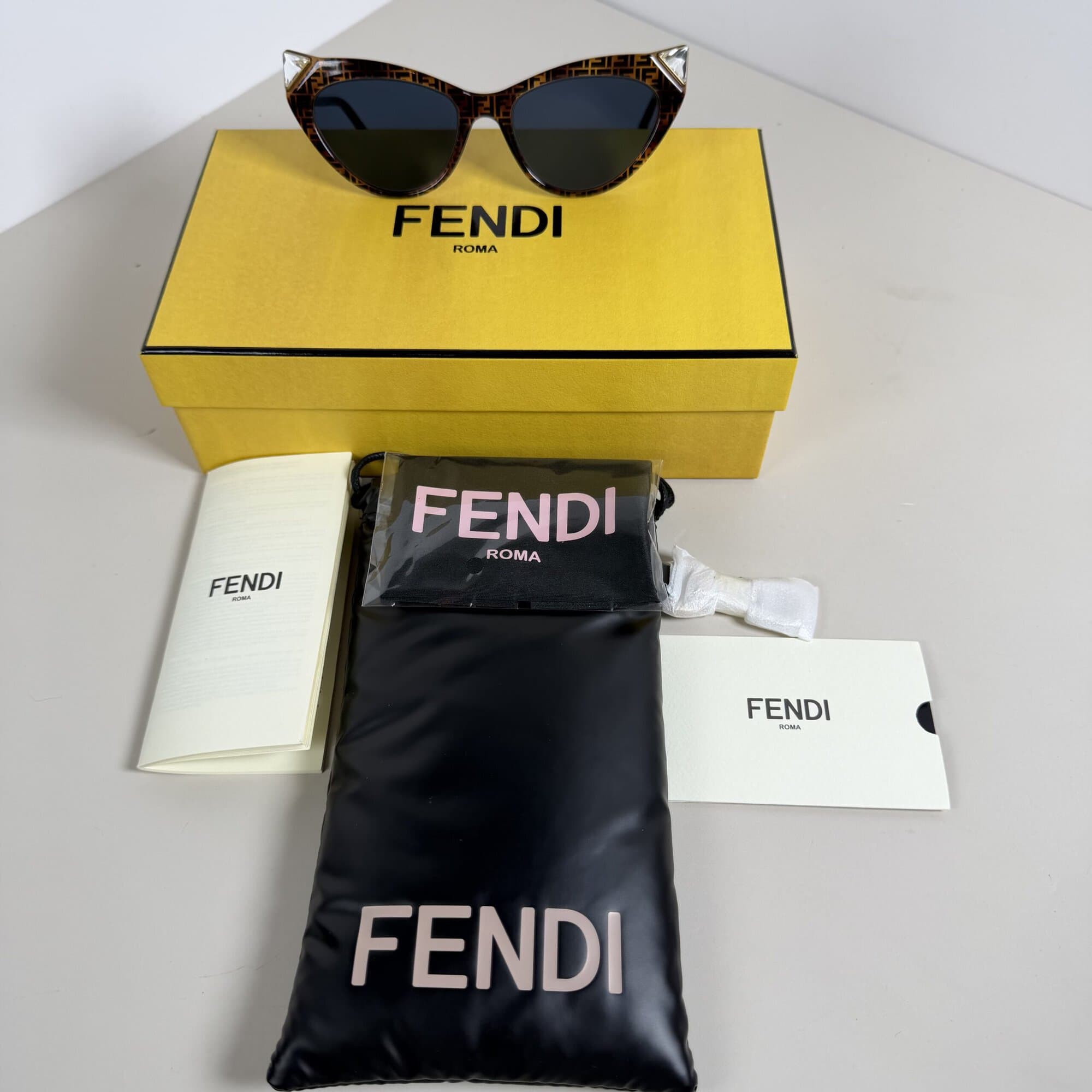 Overview of Fendi monogram sunglasses with original presentation box, pouch, and documents
