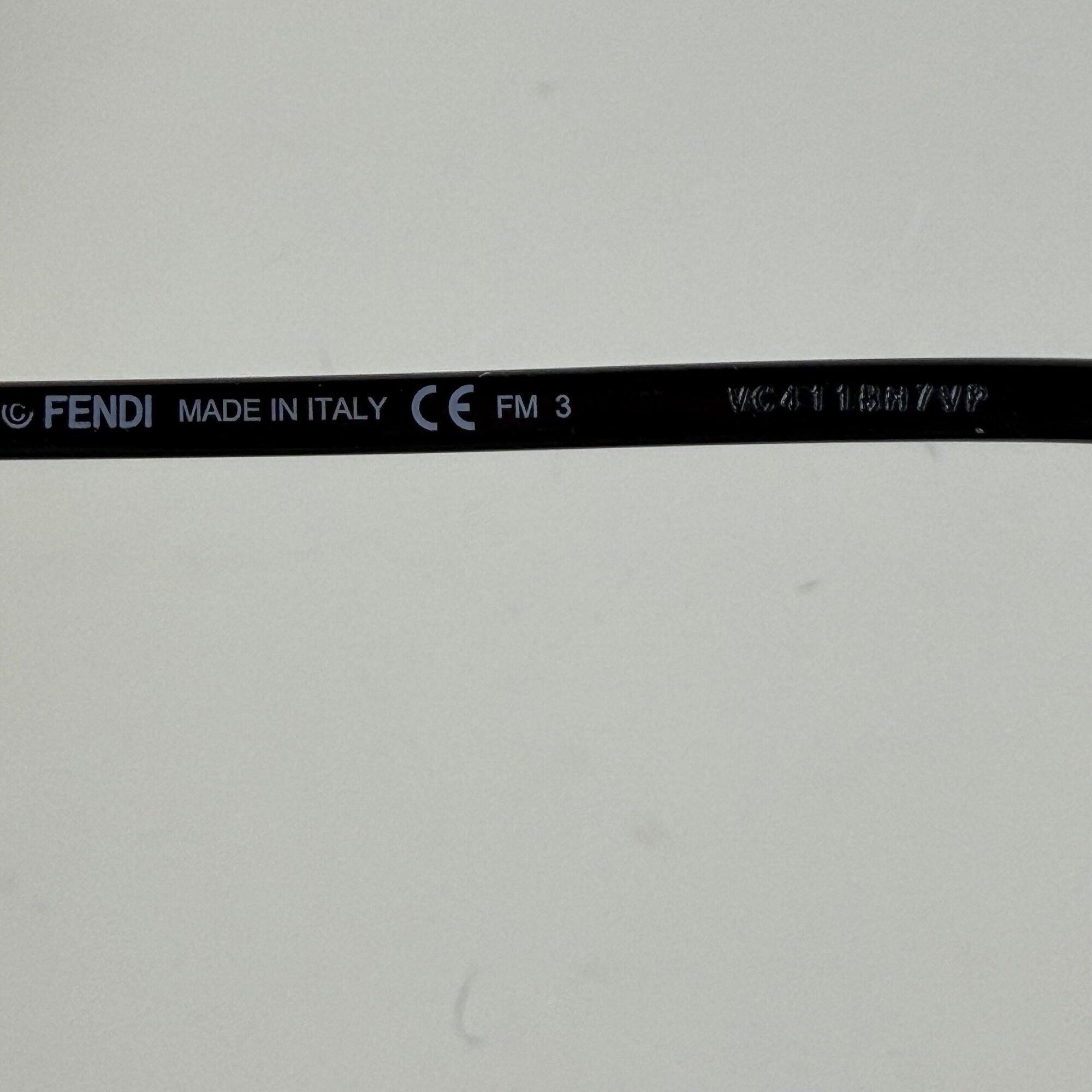 Close-up of inner right temple arm stamped Fendi Made in Italy CE and etched serial number