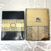 Burberrys damask quilted comforter folded inside its box next to the branded check-banded lid.