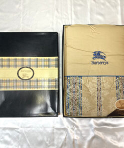 Burberrys damask quilted comforter folded inside its box next to the branded check-banded lid.