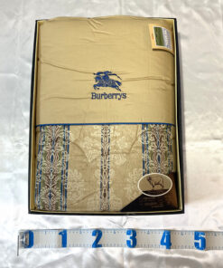 Burberrys quilted comforter in packaging box with measuring tape along the lower edge.