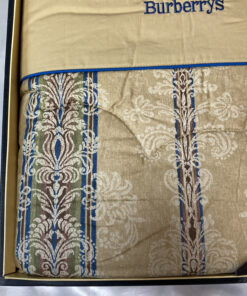 Close-up of the beige and blue damask jacquard textile weave with quilted stitching.