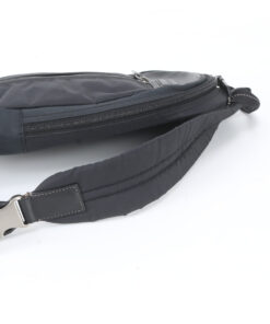 Side view of Coach sling pack showing side zipper and strap buckle