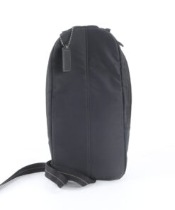Rear view of Coach black sling pack showing back panel and hangtag