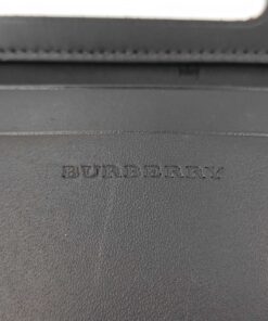 Close-up of blind debossed Burberry brand lettering on interior dark brown leather.