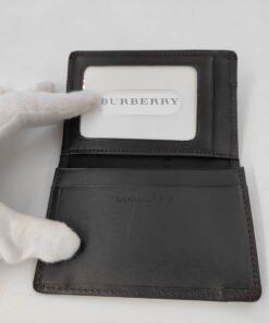 Interior layout of open Burberry card case showing clear ID pass window and leather slip pocket.