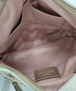 Interior compartment view showing pink textile lining, two slip pockets, zip pocket, and leather creed patch.