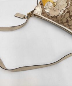 Overhead view showing metallic gold leather shoulder strap, upper rim, and hanging leather logo tag.