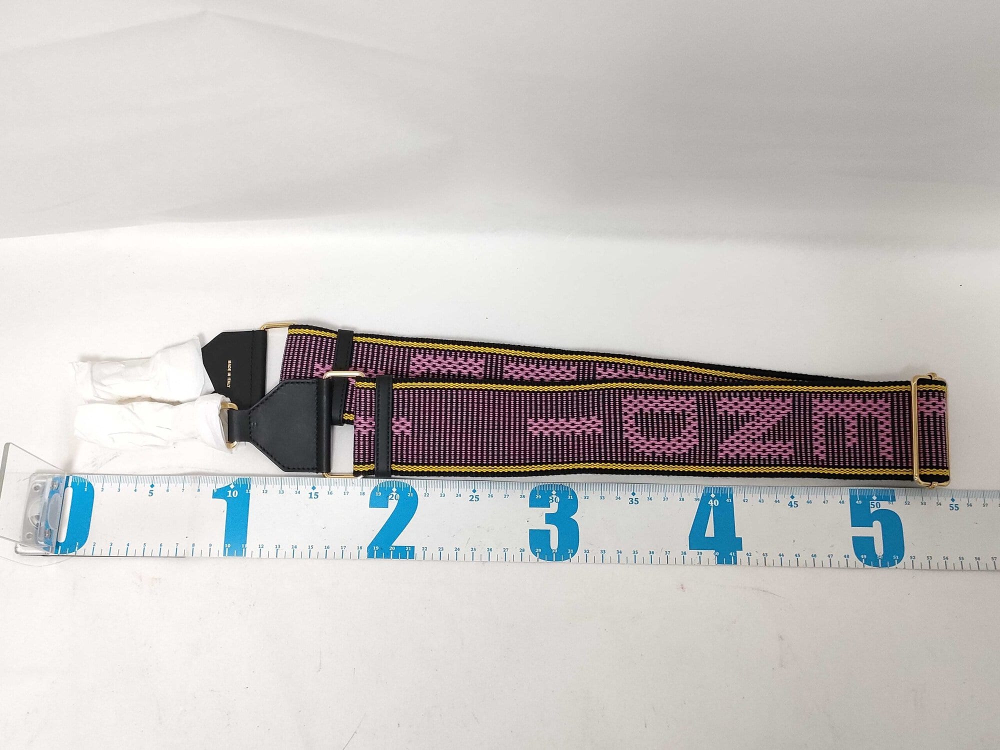 Fendi Strap You shoulder strap laid folded alongside a centimeter ruler measuring approximately 54 centimeters.