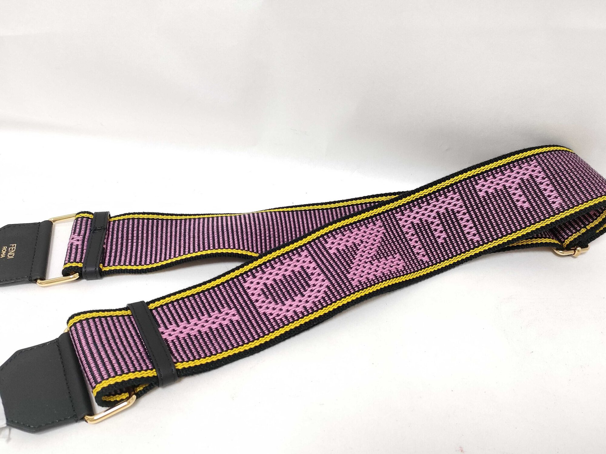 Close-up of Fendi woven jacquard logo webbing showing purple ground, pink lettering, and yellow trim.