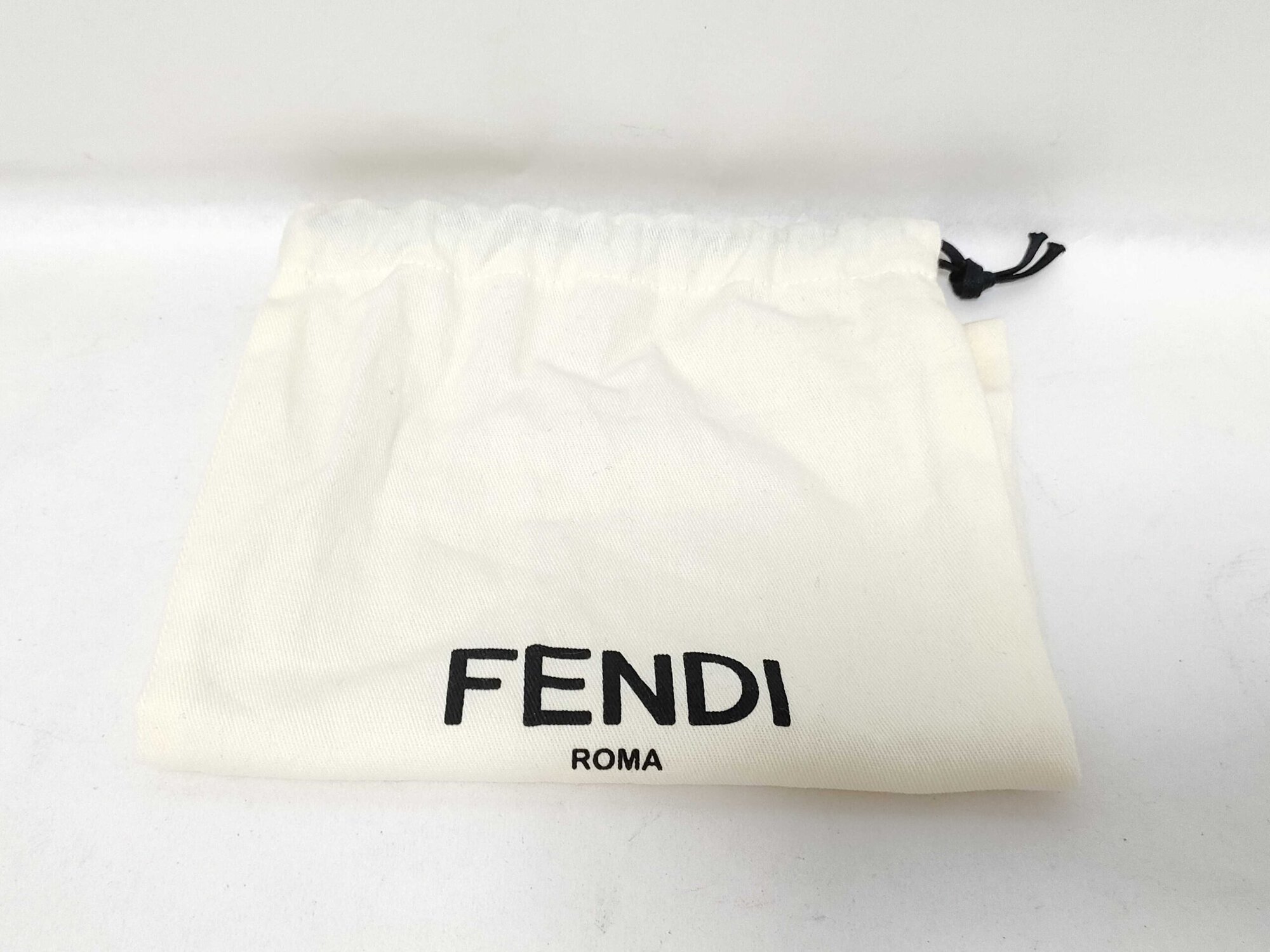 Cream cotton drawstring dust bag featuring printed black FENDI ROMA logo.