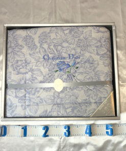 Christian Dior boxed comforter shown with measuring tape along bottom edge