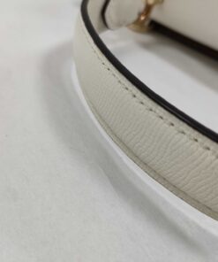 Detail of white crossgrain leather texture and edge stitching on satchel top handle
