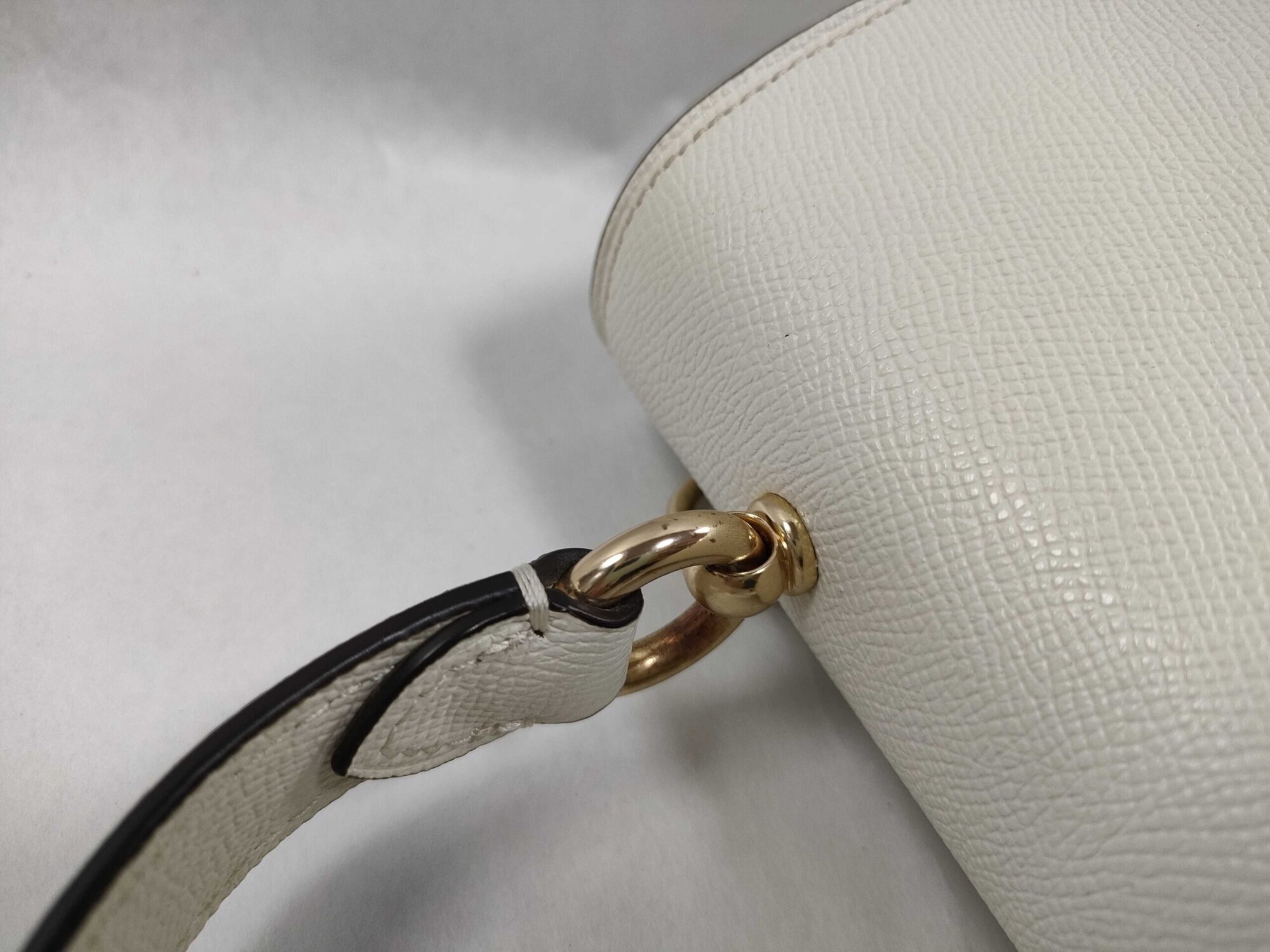 Top panel view of Coach satchel showing gold-tone ring mounting for the carry handle