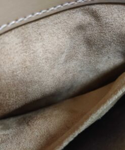 Interior tan fabric slip pocket and compartment wall inside Coach satchel