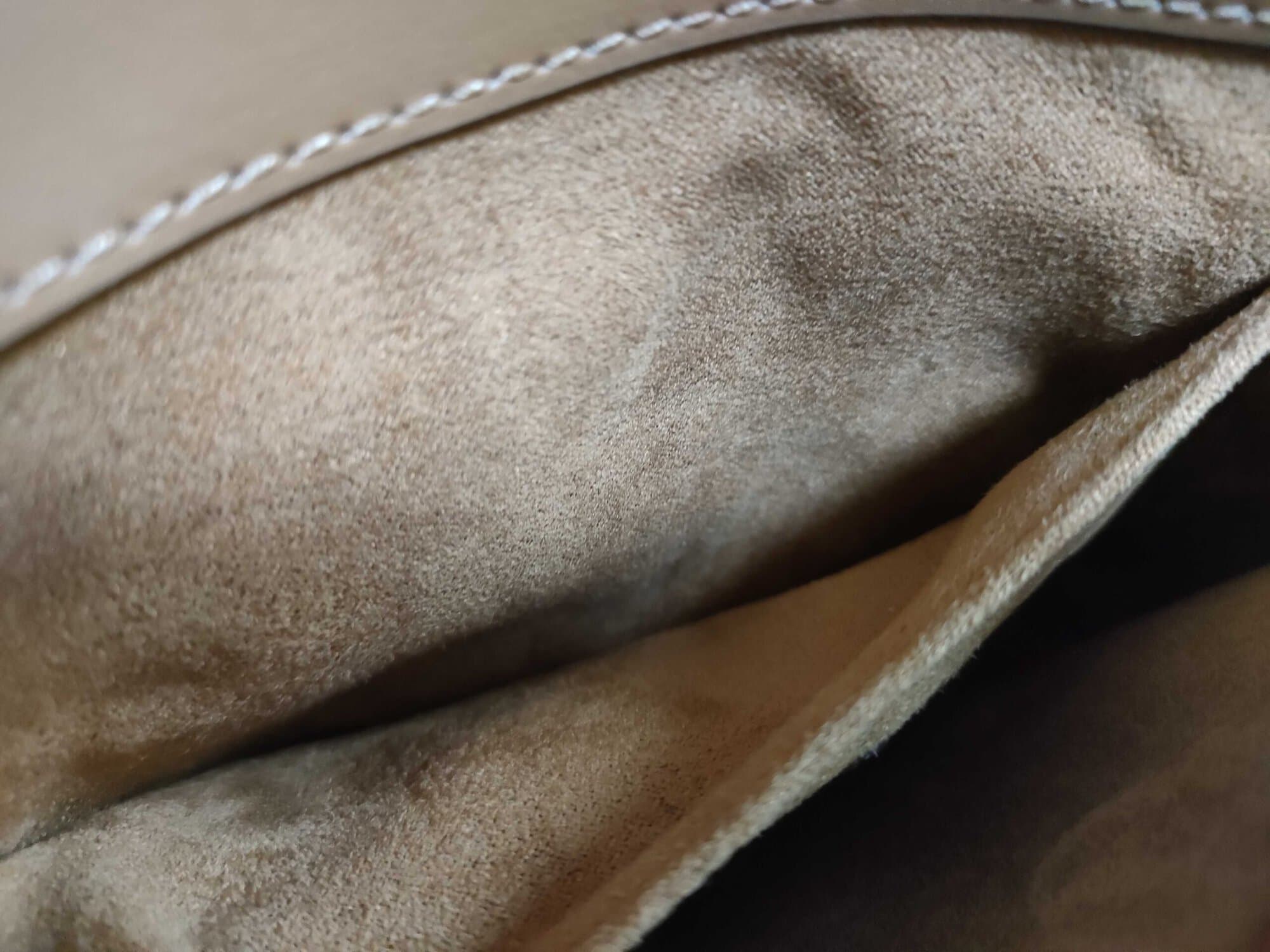 Interior tan fabric slip pocket and compartment wall inside Coach satchel
