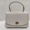 Front view of Coach Chalk White Crossgrain Leather Tilly satchel with gold-tone turnlock and top handle