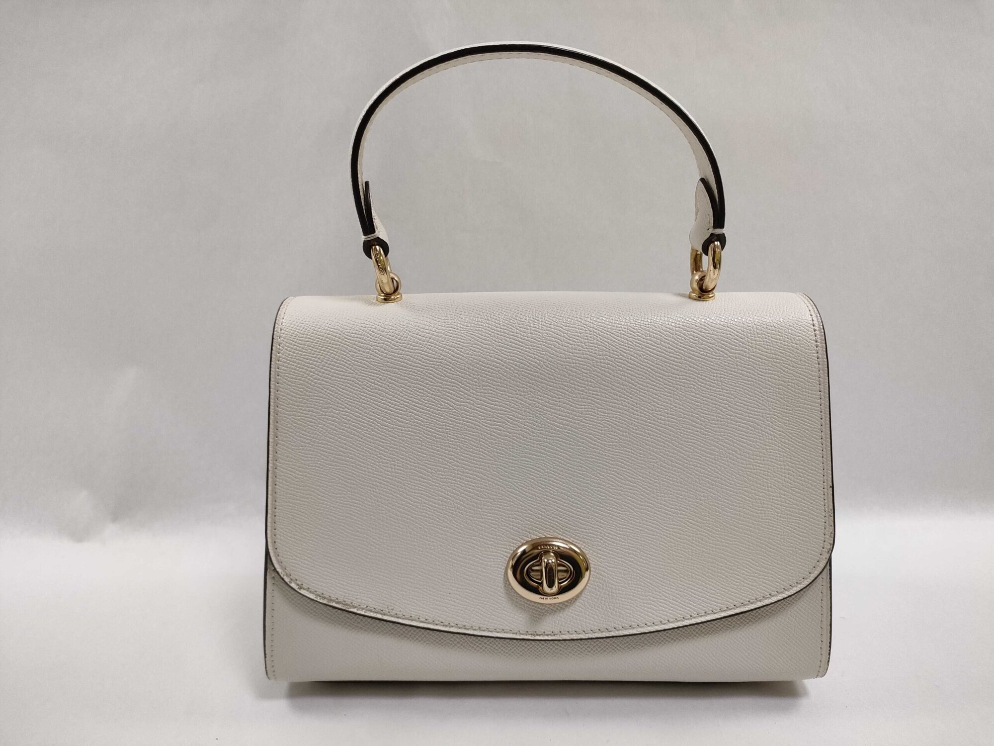 Front view of Coach Chalk White Crossgrain Leather Tilly satchel with gold-tone turnlock and top handle