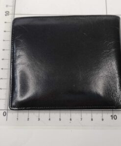 Givenchy Monsieur black leather wallet shown flat against a centimeter measuring mat