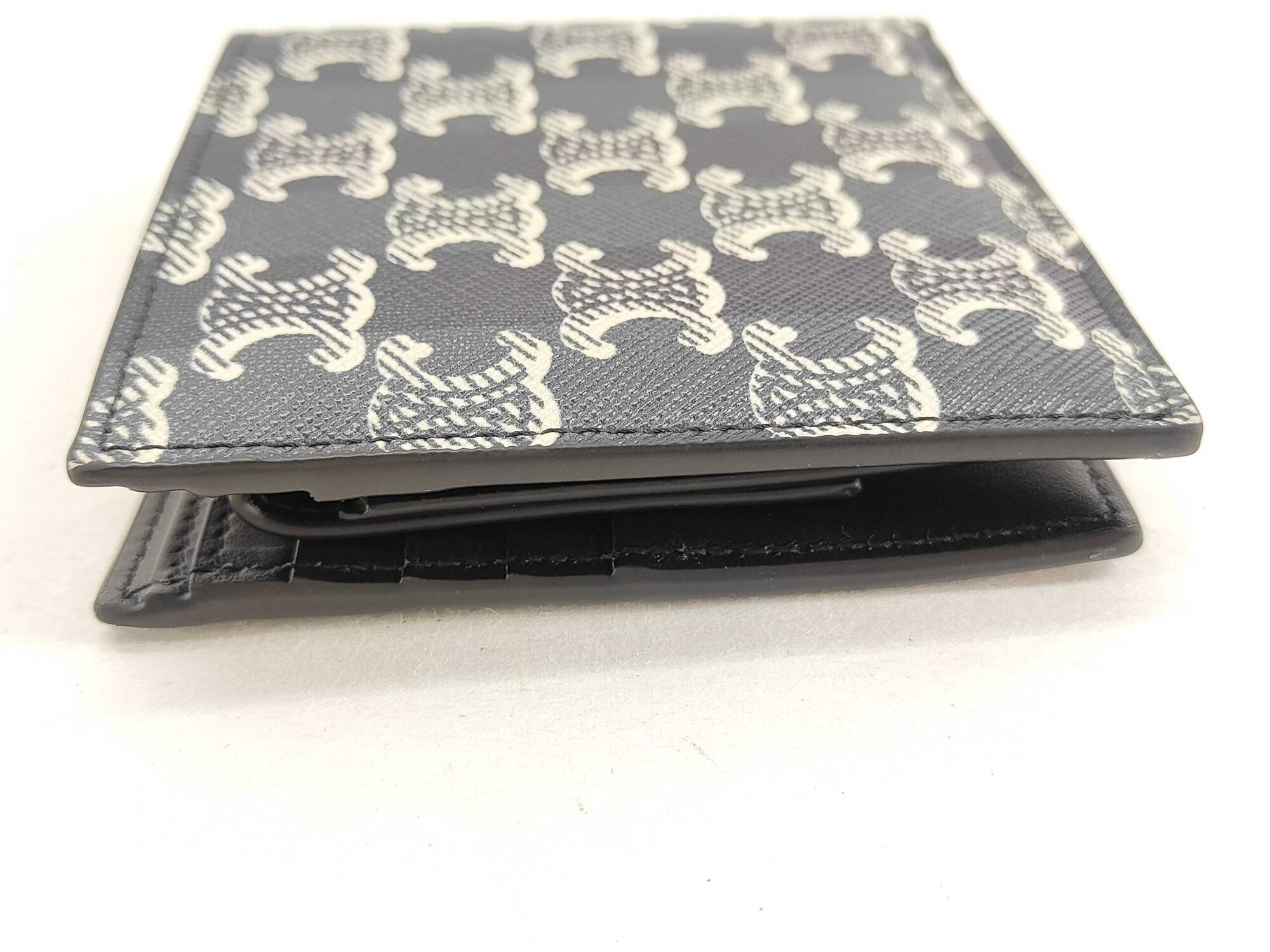 Bottom edge view of Celine Triomphe canvas bifold wallet displaying folded structure.
