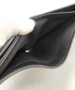 Interior view into open textile-lined billfold compartments of Celine bifold wallet.