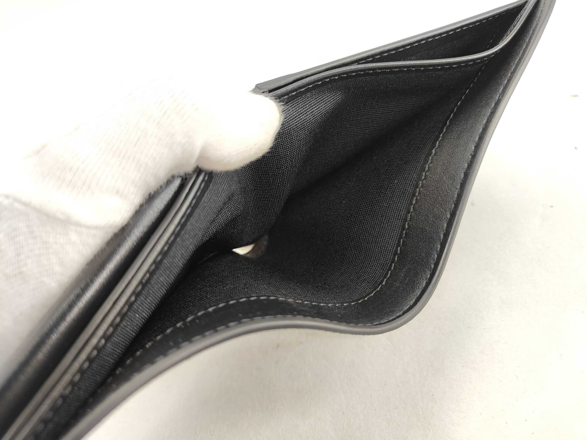 Interior view into open textile-lined billfold compartments of Celine bifold wallet.