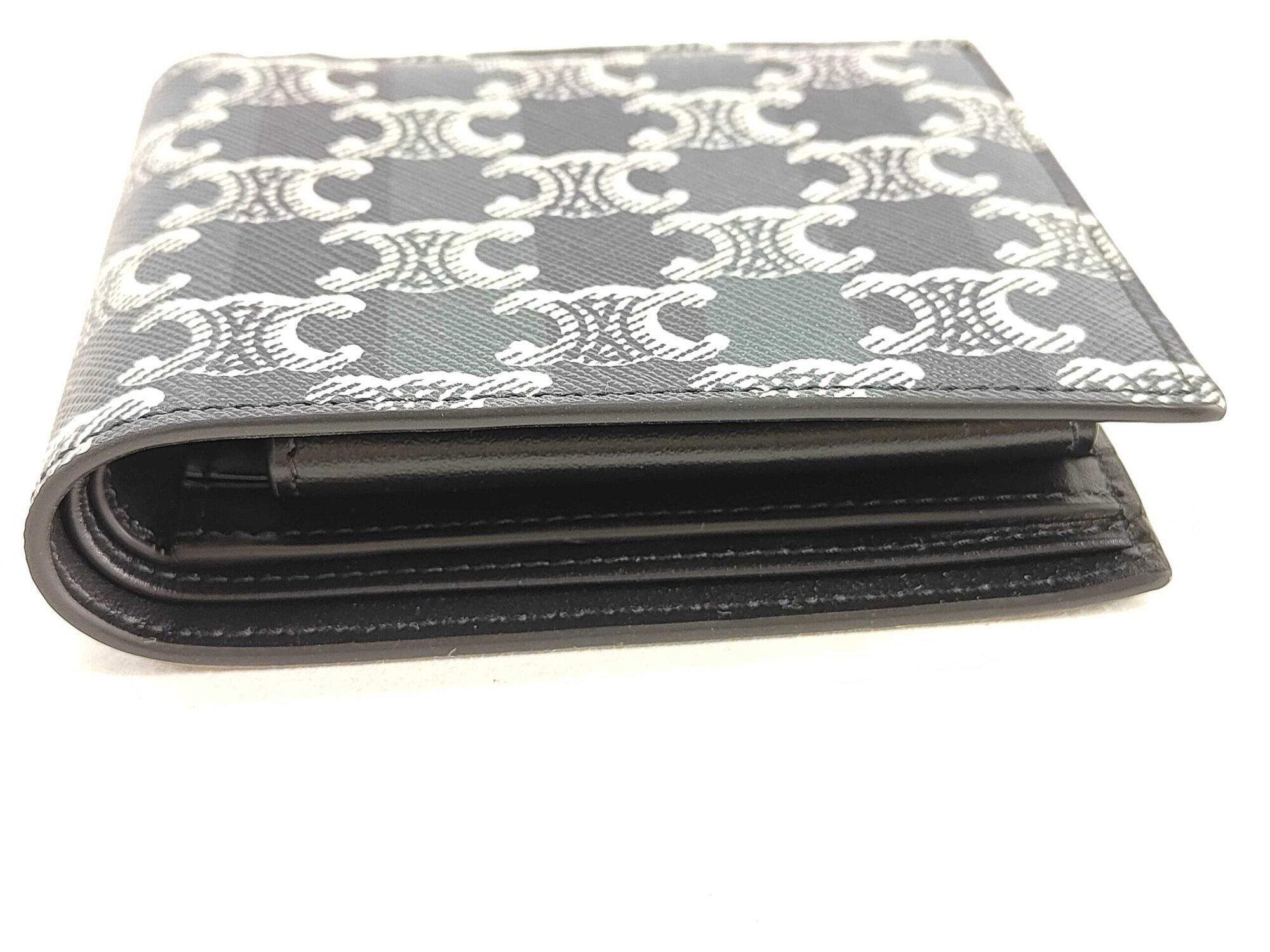Side profile view of folded Celine bifold wallet showing thickness and edge glazing.