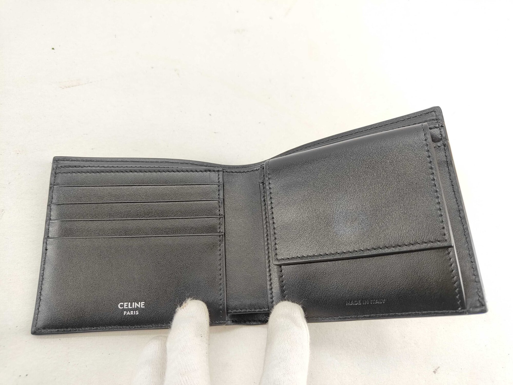 Open interior view of Celine wallet showing card slots, coin flap, and logo stamps.