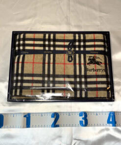 Burberrys Nova Check bath towel in box displayed next to a metric measuring tape