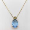 Christian Dior gold-tone pendant necklace featuring an oval light-blue faceted stone crowned with clear accent stones.