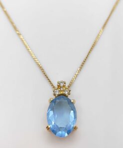 Christian Dior gold-tone pendant necklace featuring an oval light-blue faceted stone crowned with clear accent stones.