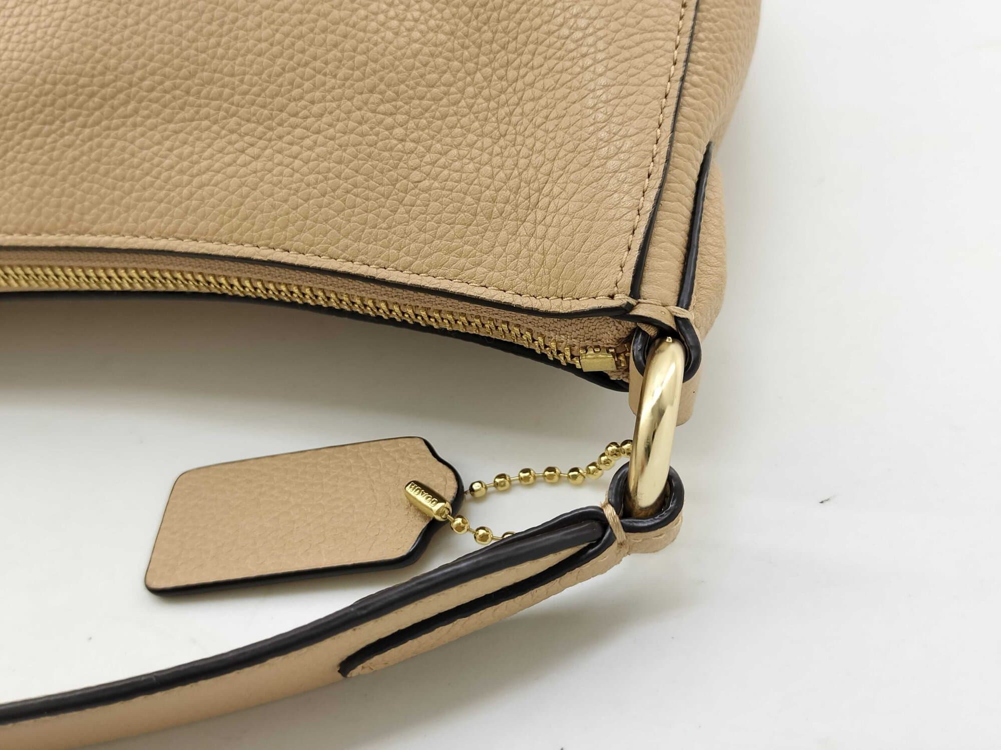 Close-up of shoulder strap ring attachment and Coach leather hangtag