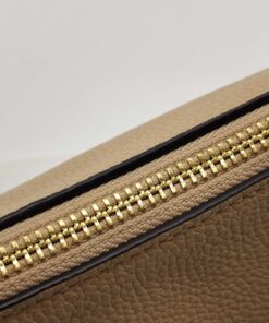 Close-up of gold-tone zipper teeth and fabric track along bag opening