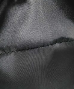 Interior view of black fabric lining inside central zippered coin pocket.