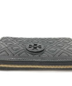 Top view of closed gold-tone zipper track along perimeter of black leather Tory Burch wallet.