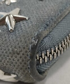 Close-up of bottom corner piping showing surface rubbing wear on Jimmy Choo wallet.