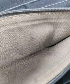 Interior view of center zippered coin pocket showing light fabric lining with minor marks.