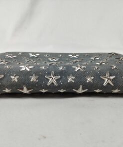 Bottom edge of Jimmy Choo Filipa wallet showing textured glitter leather and star studs.