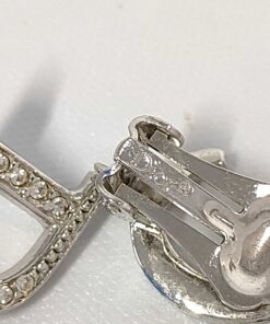 Close-up of Christian Dior paddle clip backing showing engraved Dior copyright hallmark.