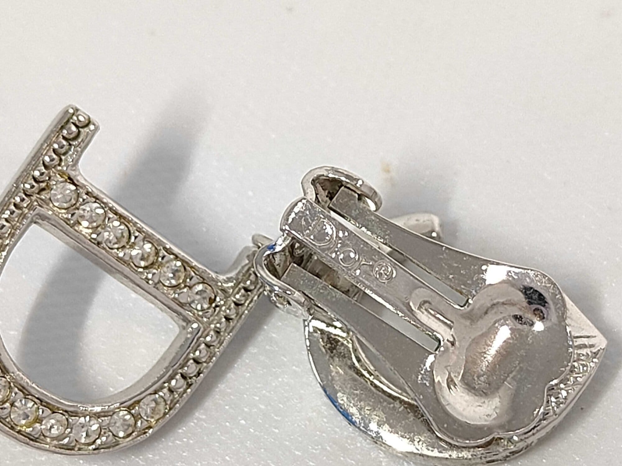 Close-up of Christian Dior paddle clip backing showing engraved Dior copyright hallmark.
