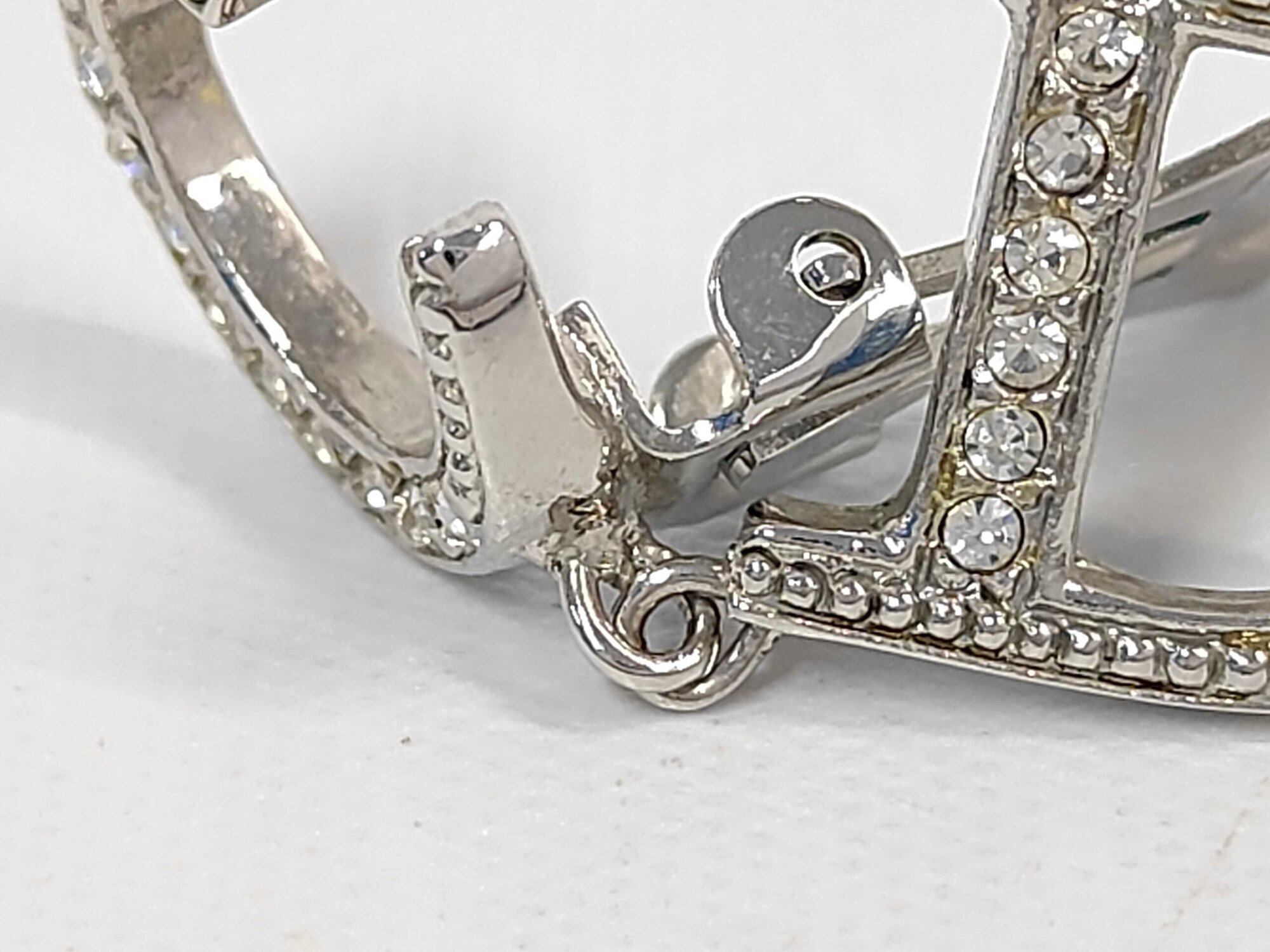 Detailed view of clear pavé-style stone settings and connecting link between C stud and D drop.