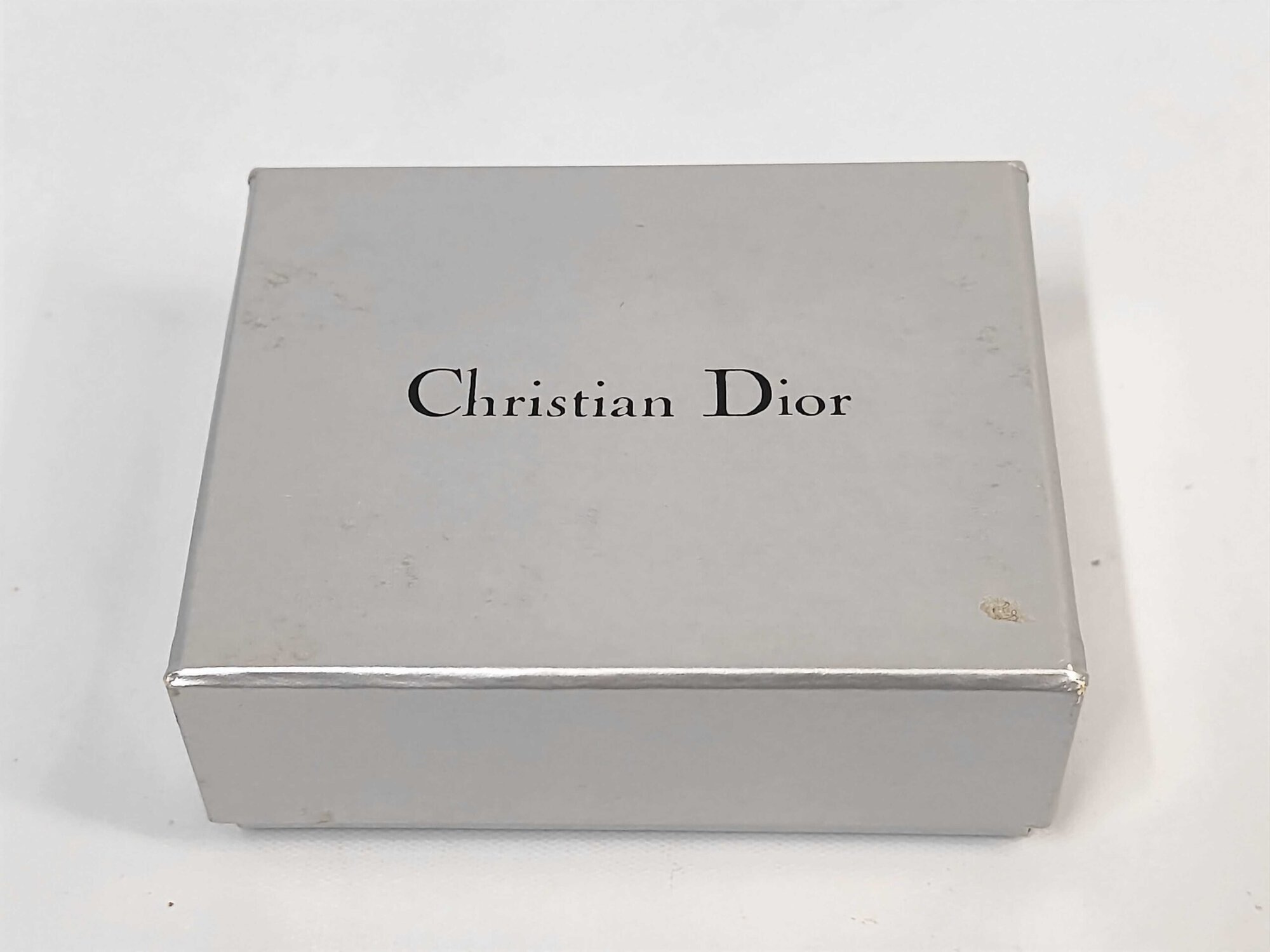 Christian Dior silver-tone presentation box with black printed logo on the lid.