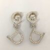 Front view of Christian Dior CD logo drop clip-on earrings in silver-tone metal with clear accents.