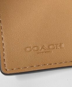 Close-up of debossed Coach New York logo on tan leather interior.