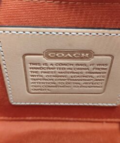 Interior debossed leather Coach creed patch on orange fabric