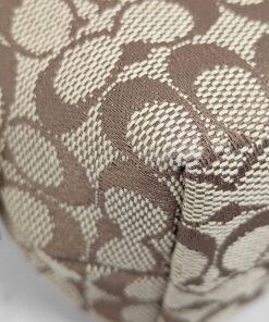 Close-up of bottom corner woven fabric on Coach signature pouch