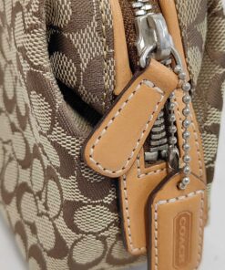 Side view showing silver-tone zipper, leather pull, and hangtag