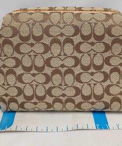 Coach signature canvas cosmetic pouch positioned above measuring ruler