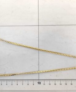 Christian Dior necklace arranged in loop on measuring grid.