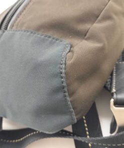 Close-up of lower bottom corner showing dark brown nylon and black edge trim.